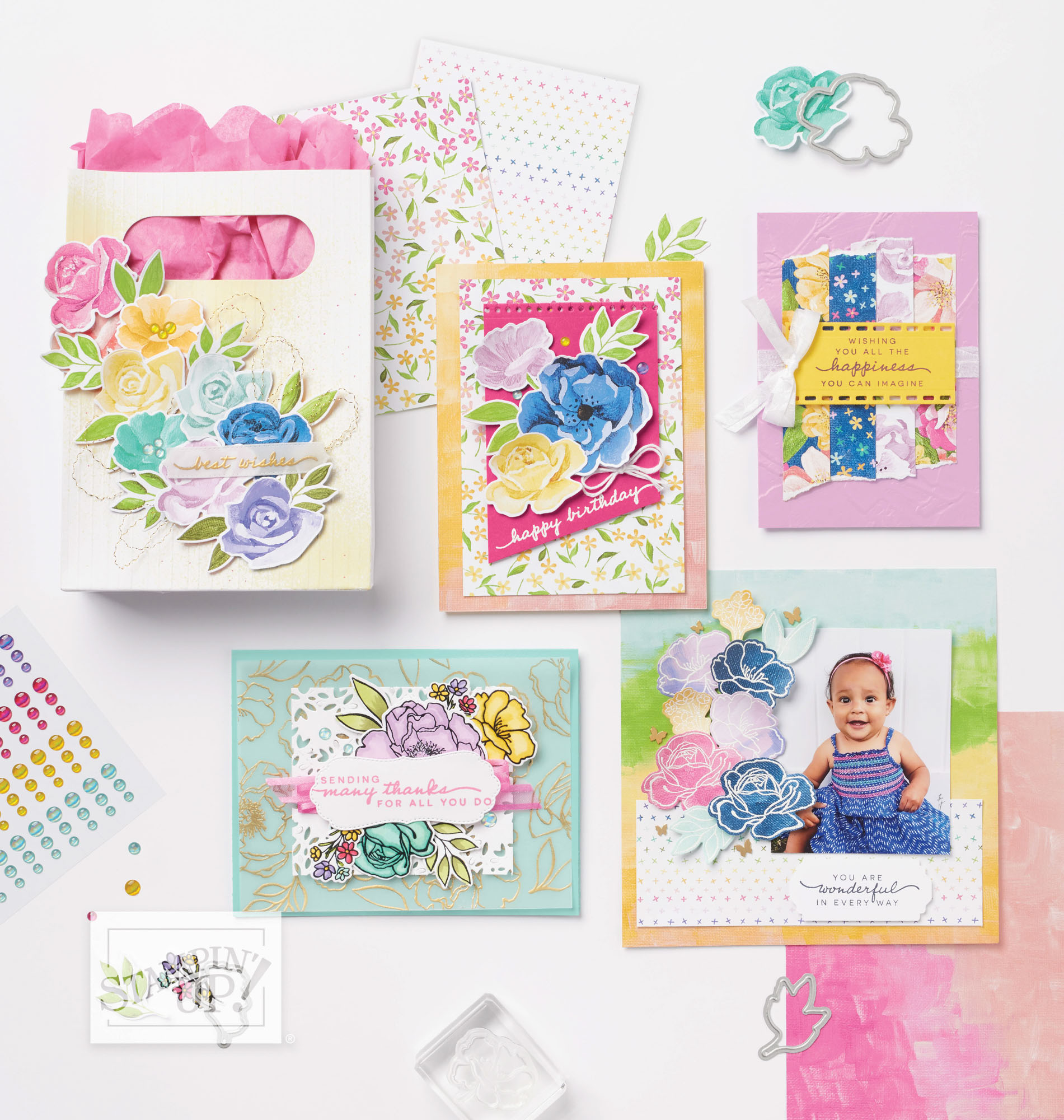 "Coordinated gift bag and greeting cards featuring vibrant floral die cuts, patterned papers, and stamped sentiments like 'happy birthday' and 'best wishes.' Projects showcase layered designs using bright colors, floral elements, and embellishments including rhinestones and ribbon."

